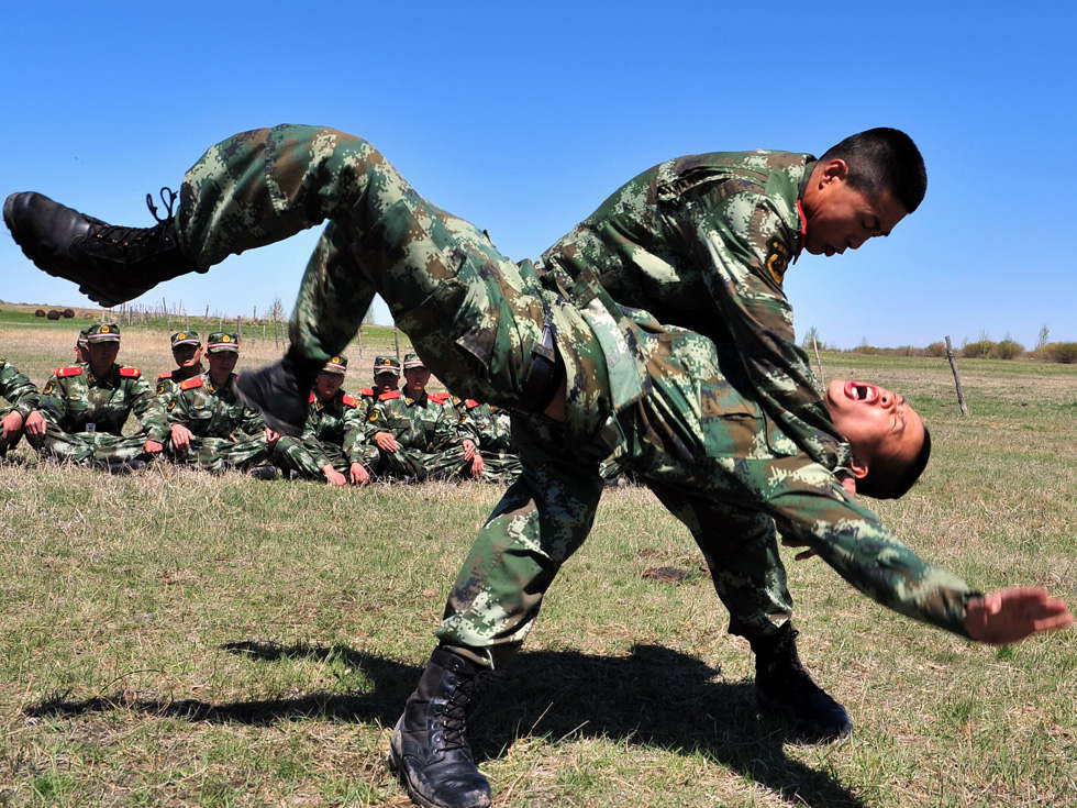 Armed border police officers take an anti-terror training on the prairie in Hulun Buir, Inner Mongolia on May 25, 2013. (Xinhua Photo/ Cui Linyi)