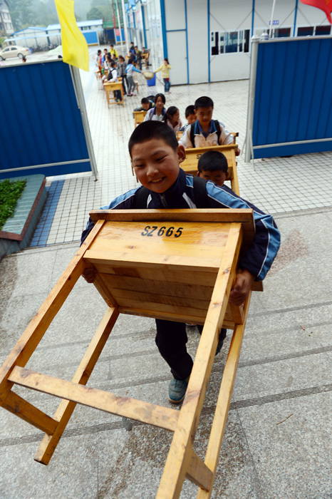 Students put the tables in the reinforced classroom building in Ya'an, southwest China’s Sichuan province, May 24, 2013. A 7.0-magnitude earthquake  struck the county on April 20, leaving many people dead and injured. (Xinhua Photo/ Li Xiangyu)