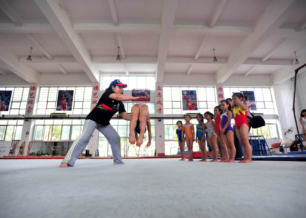 Retired gymnast Cheng Fei (left) coaches a girl, May 28, central China’s Wuhan city. Cheng was a three-time World Champion on the vault. She was also a member of the gold medal-winning Chinese teams for the 2008 Olympic Games in Beijing. Since May, Cheng has become a teacher in Wuhan Sports University with a mission to change gymnastics into a sport for all. (Xinhua/Cheng Min)