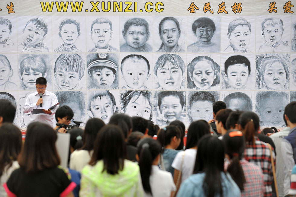 Citizens view the public notice searching for missing children in Taiyuan, Shanxi province on May 26, 2013. Those notices and photos are post by a  voluntary group of parents whose children are missing. (Xinhua photo/ Zhan Yan)