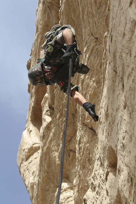A photo taken on May 27 shows a solider rappelling from a cliff as he takes part in a routine exercise in northwest China’s Xinjiang. (Xinhua/Li Xiang)