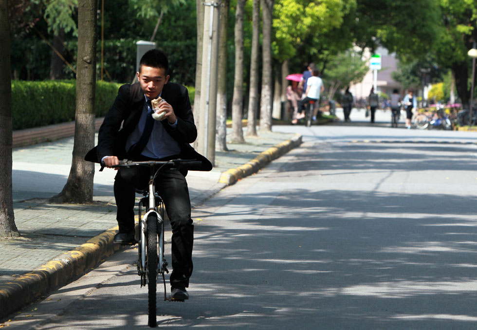 Liao Weidong, 22, a senior student in Fudan University heads to the company where he works as an intern on the morning of May 25, 2013. He has sent  his resume to over 110 companies and has been interviewed 10 times within three months. A record 7 million students will graduate from college in  China this year, up 2.8 percent year on year. Meanwhile, the average employment rate for graduates with bachelor's degrees stood at 35 percent, down  12 percentage points compared with the same period of last year. (Xinhua Photo/ Ding Ting)