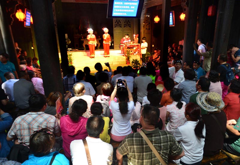 Tourists enjoy a program on intangible heritage about traditional folk customs inside a folk pavilion at the Mount Phoenix scenic area in Zigui county, Hubei province, June 2, 2013. (Xinhua)