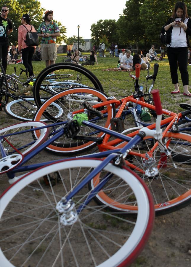 Bikes are seen on the ground as their owners watch performance of SummerStage festival in the Brooklyn borough of New York, the United States, June 4, 2013. With a history of over 20 years, SummerStage, a program of City Parks Foundation, presents performances of outstanding artistic quality free of charge to serve the diverse communities of New York City. (Xinhua/Cheng Li) 
