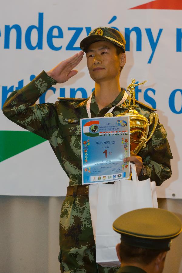 Wang Zhanjun of China poses with his trophy during the awarding ceremony at the 12th Police and Military Sniper World Cup in Budapest, Hungary, on June 4, 2013. Wang won the gold medal of Individual Military competition of the event. (Xinhua/Attila Volgyi) 