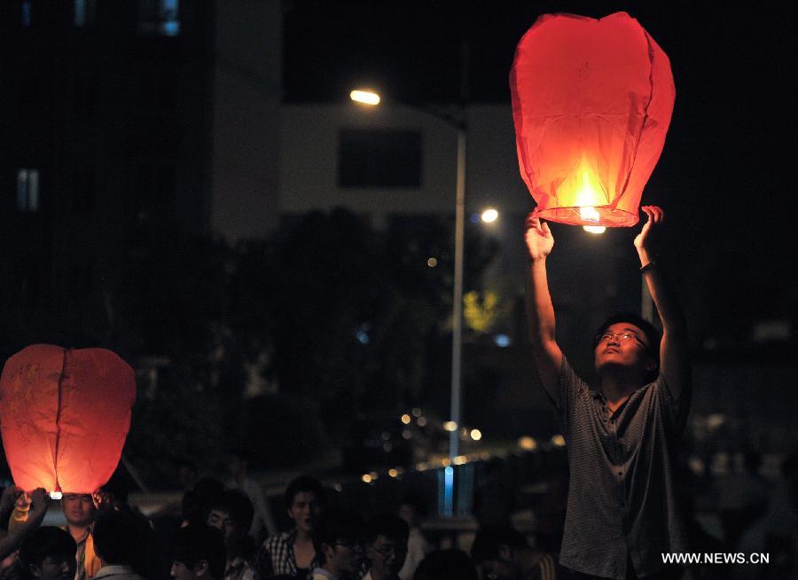 A high school graduate flies a sky lantern, wishing for good luck in the coming national college entrance exams in Maotanchang Township of Lu'an City, east China's Anhui Province, June 4, 2013. High school graduates will take part in the national college entrance exams set for June 7-8. (Xinhua/Guo Chen)