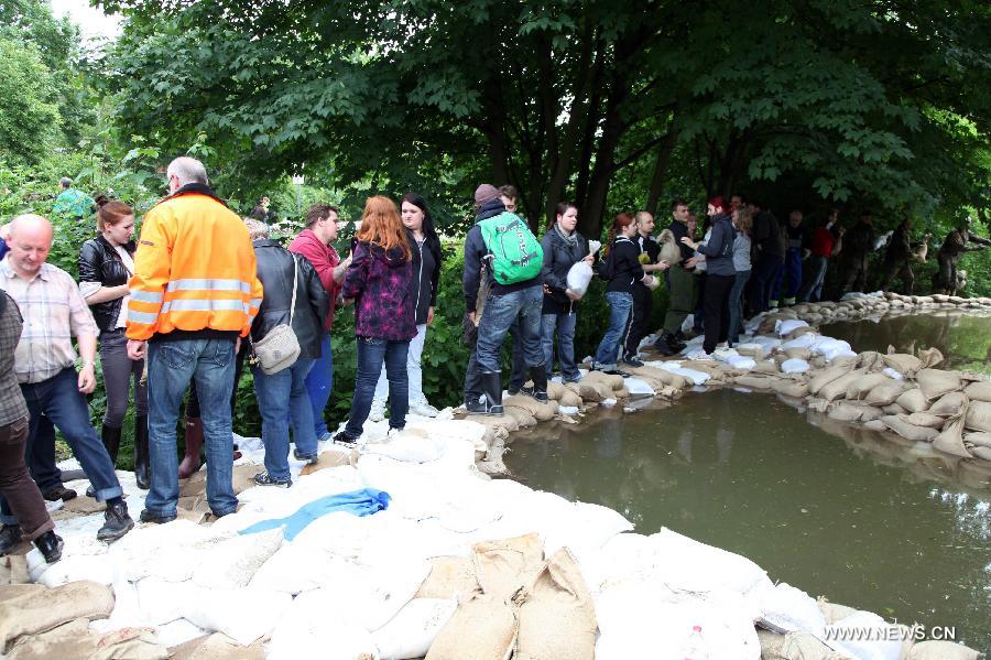 German Bundeswehr soldiers and local volunteers line up to pass on sandbags to beef up the dike at Gimritzer Dammin in Halle, eastern Germany, on June 4, 2013. The water level of Saale River across Halle City is expected to rise up to its historical record of 7.8 meters in 400 years, due to persistent heavy rains in south and east Germany. (Xinhua/Pan Xu)  