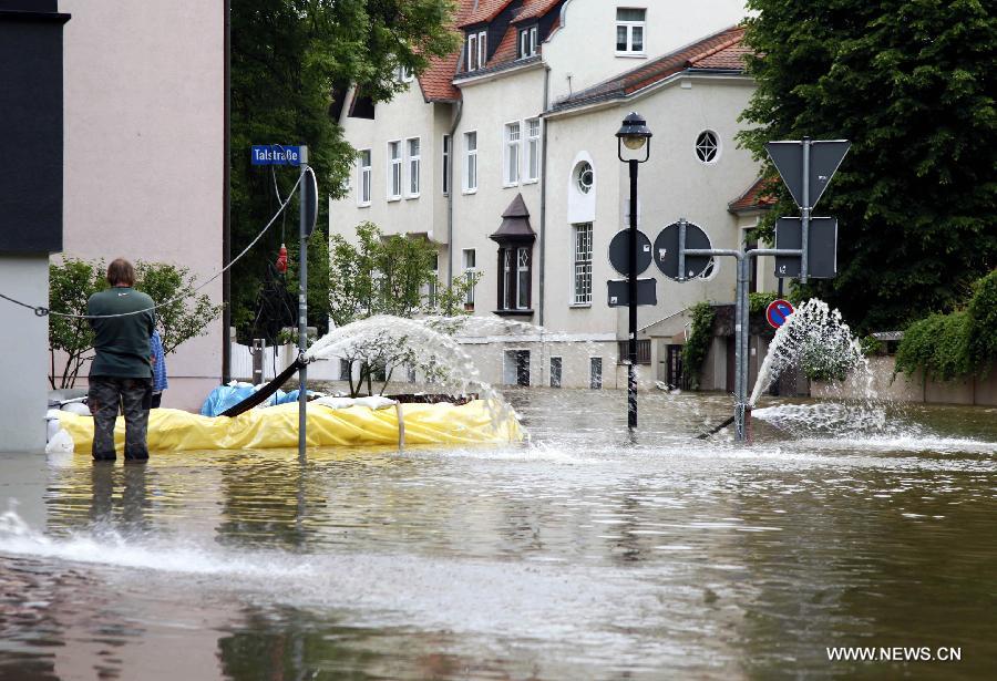 Workers drain water with pump from the evacuated residential building on the flooded street in Halle, eastern Germany, on June 4, 2013. The water level of Saale River across Halle City is expected to rise up to its historical record of 7.8 meters in 400 years, due to persistent heavy rains in south and east Germany. (Xinhua/Pan Xu)