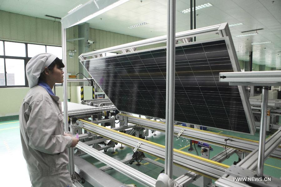 A worker checks the solar photovoltaic products which will be exported to Europe at an energy company in Lianyungang City, east China's Jiangsu Province, June 4, 2013. On Tuesday, the European Commission announced its decision to introduce anti-dumping duties of 11.8 percent on solar panels imported from China. (Xinhua/Si Wei) 