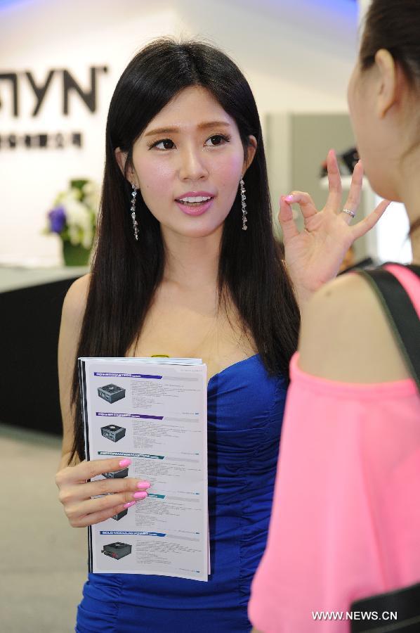 An employee gives a brief introduction of their products to a visitor at Computex Taipei 2013 exhibition, in Taipei, southeast China's Taiwan, June 4, 2013. The five-day exhibition opened here on Tuesday. (Xinhua/Tao Ming) 