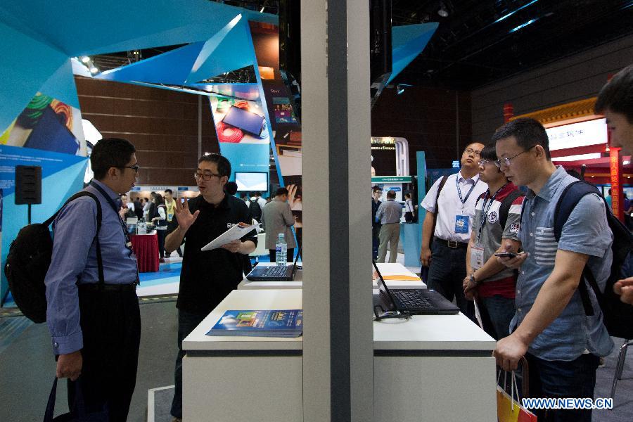 People visit the exhibition area of cloud computing service during the 5th China Cloud Computing Conference in Beijing, capital of China, June 5, 2013. The conference kicked off on June 5. (Xinhua/Liu Xin)