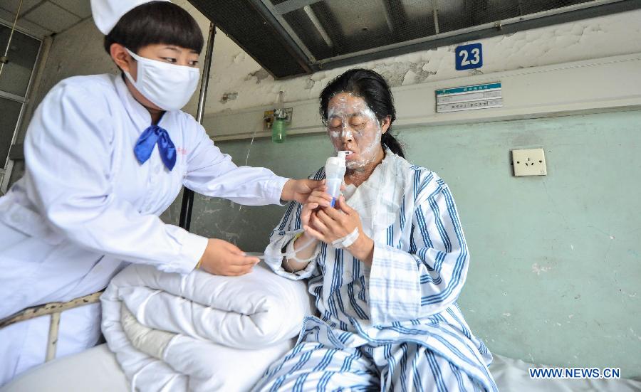 Wang Fengya, a woman injured in a fire accident, receives medical treatment in hospital in Changchun, capital of northeast China's Jilin Province, June 5, 2013. A fire broke out at a poultry processing workshop owned by the Jilin Baoyuanfeng Poultry Company in Mishazi Township in the city of Dehui on early Monday morning. The fire killed 120 people and injured 77 others. (Xinhua/Wang Haofei)