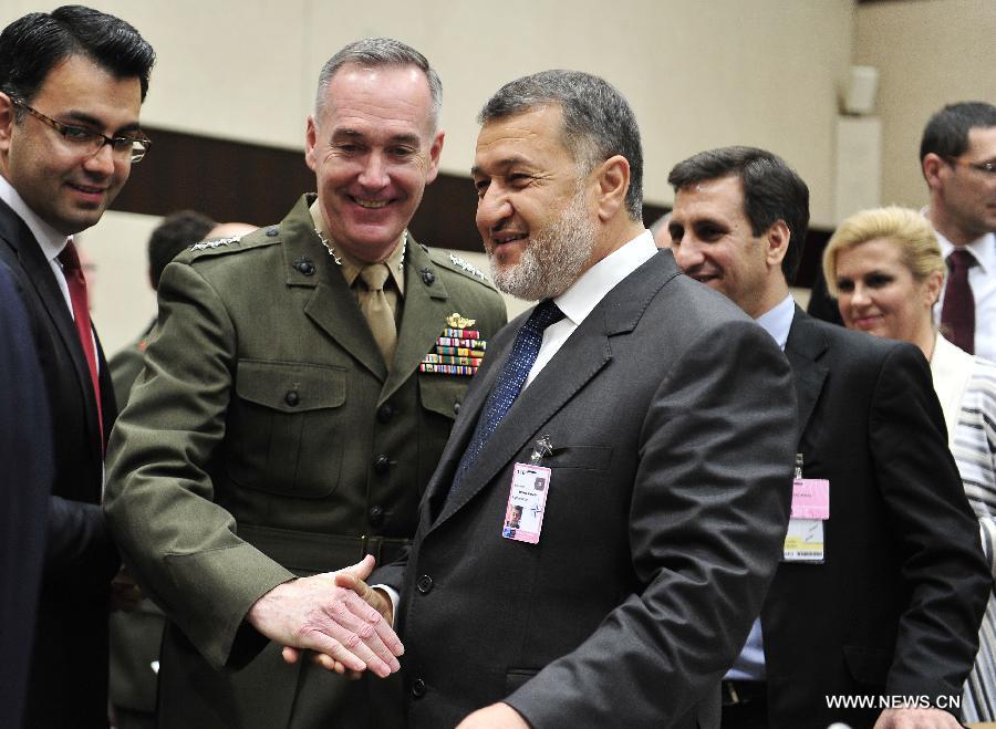 Afghan Defence Minister Bismillah Khan Mohammadi (central R) shakes hands with Command of ISAF in Afghanistan, U.S. General Joseph F. Dunford prior to a NATO and non-NATO ISAF contributing nations meeting during two-days NATO Defence Ministers Meeting at its headquarters in Brussels, capital of Belgium, June 5, 2013. (Xinhua/Ye Pingfan)