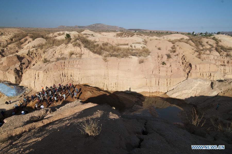 Workers are seen in a sapphire mine in Ilakaka town, the famous sapphire town in southwest Madagascar, on May 31, 2013. Since the discovery of alluvial sapphire deposits in 1998, the population had boomed from 40 residents to near 60,000 by 2005, including many businessmen from Thailand, India, France, China, etc., most of whom dreamed to become rich in one night to find sapphires. Madagsacar, famous for its sapphire production, stood alongside Australia as one of the world's two largest sapphire producers at its peak period. There are still sapphire mines operating around Ilakaka, but most deposits are located deeper below the surface now, and miners have to work much harder to extract sapphires. Due to the deep location and political crisis, Madagascar has not managed to regain its former glory as a primary producer of sapphires. (Xinhua/He Xianfeng)