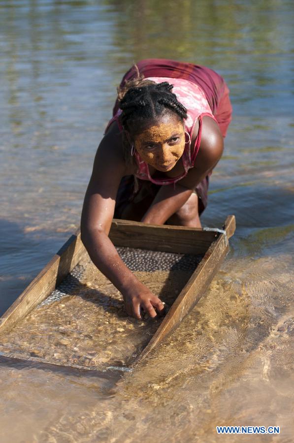 A woman looks for sapphire in a river in Ilakaka town, the famous sapphire town in southwest Madagascar, on May 31, 2013. Since the discovery of alluvial sapphire deposits in 1998, the population had boomed from 40 residents to near 60,000 by 2005, including many businessmen from Thailand, India, France, China, etc., most of whom dreamed to become rich in one night to find sapphires. Madagsacar, famous for its sapphire production, stood alongside Australia as one of the world's two largest sapphire producers at its peak period. There are still sapphire mines operating around Ilakaka, but most deposits are located deeper below the surface now, and miners have to work much harder to extract sapphires. Due to the deep location and political crisis, Madagascar has not managed to regain its former glory as a primary producer of sapphires. (Xinhua/He Xianfeng)