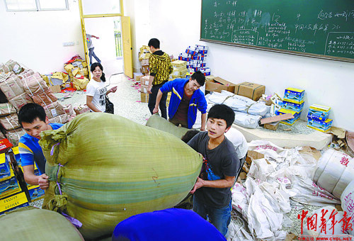 Several students in Grade 12 help their teacher carry disaster relief supplies in Baoxing High School. A 7.0-magnitude earthquake jolted Sichuan on April 20, leaving at least 192 people dead and 23 missing. More than 11,000 people were injured. (Photo/ China Youth News)