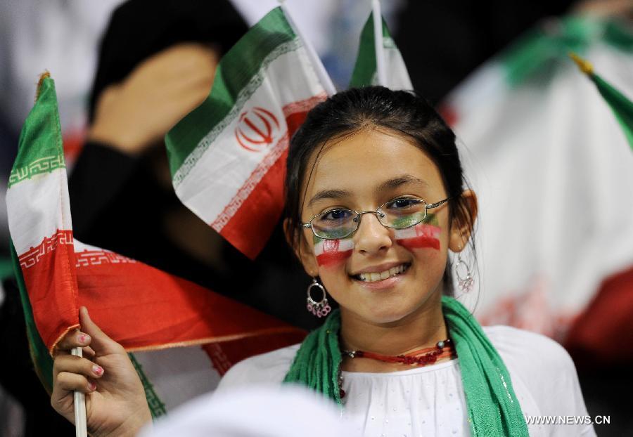 A fan of Iran waves the Iranian national flag during the 2014 World Cup qualifying soccer match between Iran and Qatar in Doha, capital of Qatar, June 4, 2013. Iran won 1-0. (Xinhua/Chen Shaojin)
