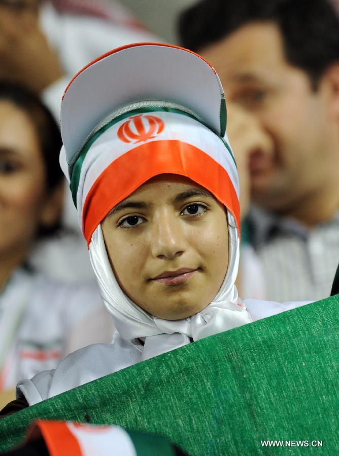 A fan of Iran holds the Iranian national flag during the 2014 World Cup qualifying soccer match between Iran and Qatar in Doha, capital of Qatar, June 4, 2013. Iran won 1-0. (Xinhua/Chen Shaojin)