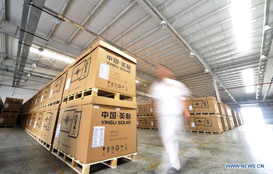 An employee walks in the storeroom of the photovoltaic products maker Yingli Solar in Tianjin, north China, June 5, 2013. Spokesman of China's Ministry of Commerce Shen Danyang said on June 5 China firmly opposes the European Commission's decision to slap provisional antidumping duties on Chinese solar panels. Shen added that it came despite herculean efforts and utmost sincerity from the Chinese side. On June 4, the European Commission announced its decision to introduce antidumping duties on solar panels imported from China. An interim punitive duty of 11.8 percent will apply to all Chinese solar panel imports starting from Thursday, and the duty will be raised to an average of 47.6 percent in two months if the two sides fail to find a solution. (Xinhua/Yue Yuewei)