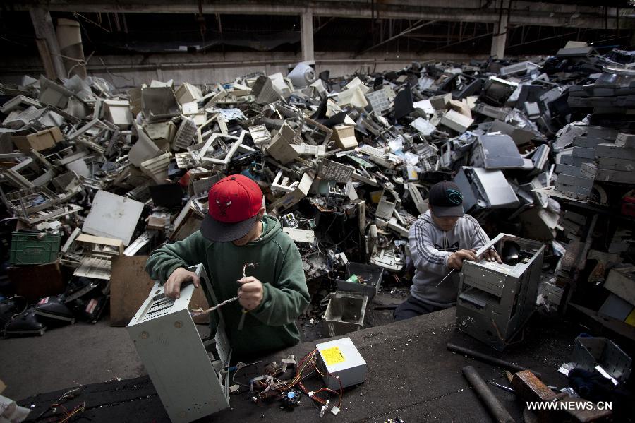 Agustin (L) and Alejandro (R), mmembers of the "La Toma" cooperative, that performs electronic waste recycling, dismantle computer parts, during the World Environment Day, in Dock Sud, Argentina, on June 5, 2013. The cooperative, created on 1972, gives job to 20 low-income people, mostly young people. The cooperative, created on 1972, gives work to 20 low-income people, mostly youngsters. The World Environment Day is celebrated yearly on June 5 to create awareness in relation to environmental issues. (Xinhua/Martin Zabala) 