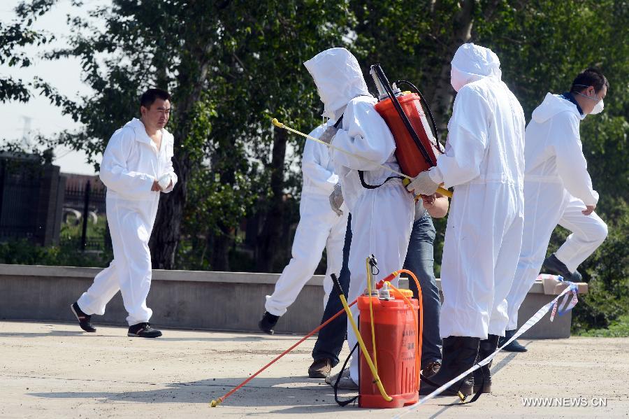 Health workers prepare to carry out disinfection work at the accident site after a fire broke out at a poultry processing workshop owned by the Jilin Baoyuanfeng Poultry Company in Mishazi Township in the city of Dehui, northeast China's Jilin Province, June 6, 2013. The fire, which occurred early Monday morning, killed 120 people and injured 77 others. (Xinhua/Lin Hong)