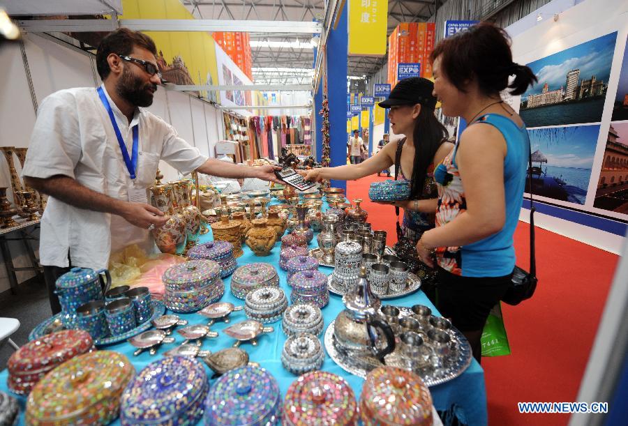 Buyers and exhibitors bargain at the first China-South Asia Expo in Kunming, capital of southwest China's Yunnan Province, June 6, 2013. The five-day China-South Asia Expo opened here on Thursday, attracting over 1,400 exhibitors from Asian countries and regions. (Xinhua/Qin Qing)