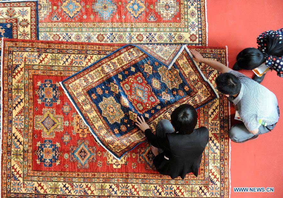 Buyers view Afghan carpets at the first China-South Asia Expo in Kunming, capital of southwest China's Yunnan Province, June 6, 2013. The five-day China-South Asia Expo opened here on Thursday, attracting over 1,400 exhibitors from Asian countries and regions. (Xinhua/Qin Qing)