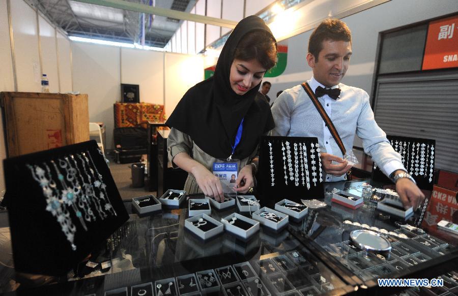 Exhibitors from Iran arrange silver ornaments at the first China-South Asia Expo in Kunming, capital of southwest China's Yunnan Province, June 6, 2013. The five-day China-South Asia Expo opened here on Thursday, attracting over 1,400 exhibitors from Asian countries and regions. (Xinhua/Qin Qing)