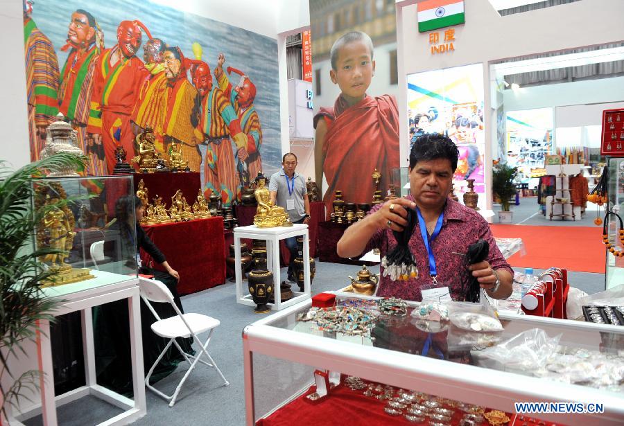 An Indian exhibitor arranges products at the first China-South Asia Expo in Kunming, capital of southwest China's Yunnan Province, June 6, 2013. The five-day China-South Asia Expo opened here on Thursday, attracting over 1,400 exhibitors from Asian countries and regions. (Xinhua/Chen Haining)