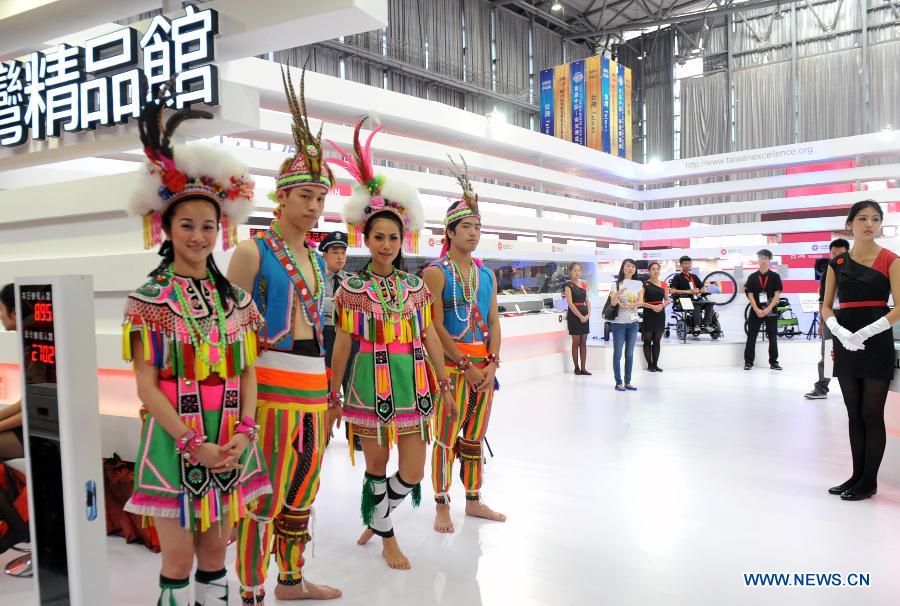 Promoters pose at the first China-South Asia Expo in Kunming, capital of southwest China's Yunnan Province, June 6, 2013. The five-day China-South Asia Expo opened here on Thursday, attracting over 1,400 exhibitors from Asian countries and regions. (Xinhua/Chen Haining)
