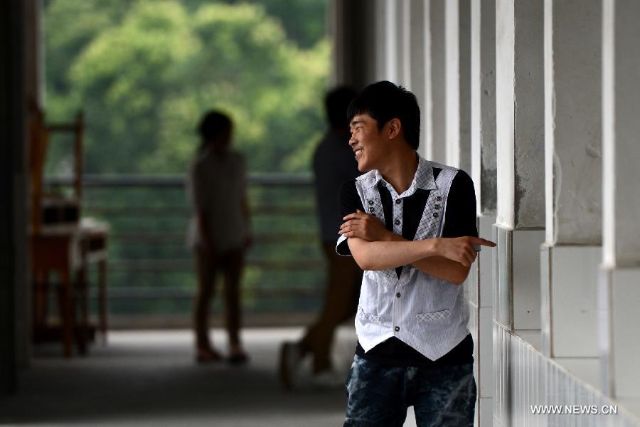 A candidate for the national college entrance exam reacts while checking his exam room at the Jinzhai No. 1 Senior High School in Liuan, east China's Anhui Province, June 6, 2013. The annual national college entrance exam will take place on June 7 and 8. Some 9.12 million applicants are expected to sit this year's college entrance exam, down from 9.15 million in 2012, according to the Ministry of Education (MOE). (Xinhua/Zhang Duan)