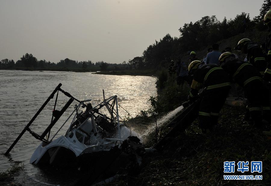 Rescuers work at the site where a helicopter crashed on the Qingbaijiang River in Guanghan City, southwest China's Sichuan Province, June 6, 2013. The crash occurred around 5:13 p.m. (GMT 0913), killing one crew member and injuring the other. The cause of the crash is under investigation. (Xinhua)