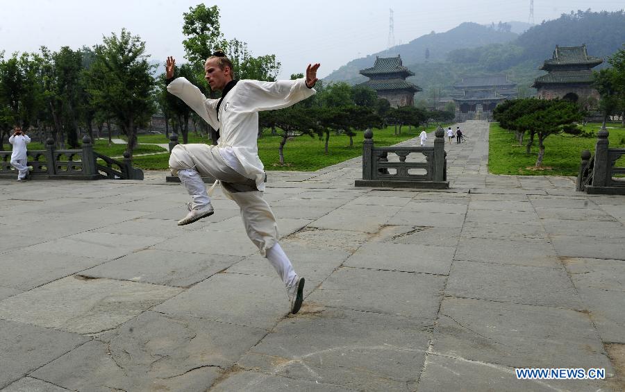 A foreign learner practises Chinese martial arts movements at the Yuxu Palace on Wudang Mountain, known as a traditional center for the teaching and practice of martial arts, in central China's Hubei Province, June 5, 2013. (Xinhua/Hao Tongqian) 