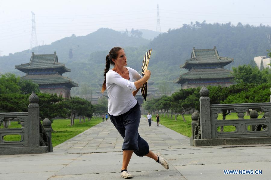 A foreign learner practises Chinese martial arts movements at the Yuxu Palace on Wudang Mountain, known as a traditional center for the teaching and practice of martial arts, in central China's Hubei Province, June 5, 2013. (Xinhua/Hao Tongqian) 