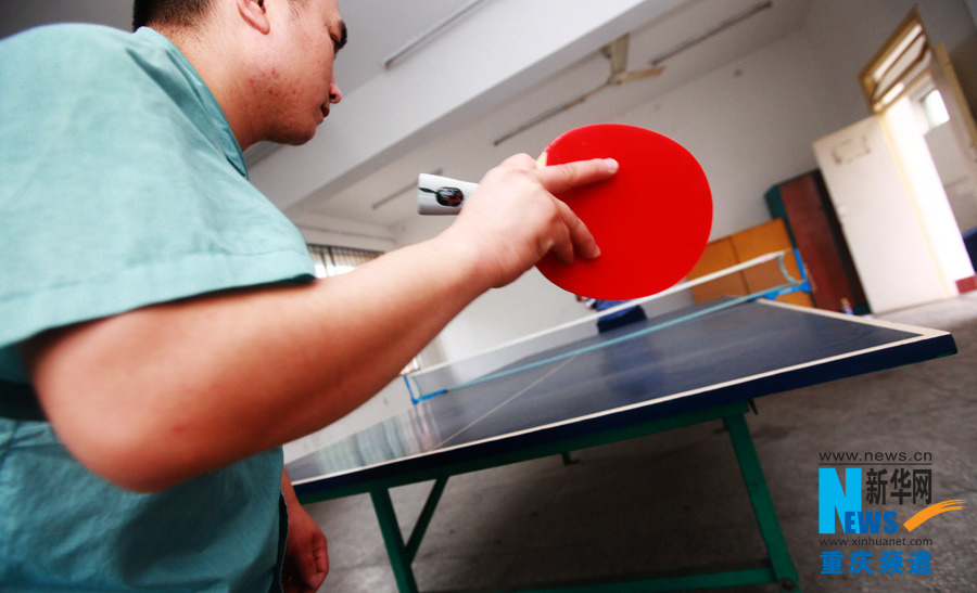 Wang plays table tennis with a police officer in Chongqing rehab center. (Photo/Xinhua)