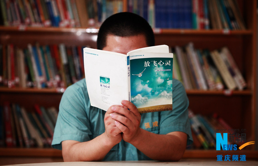 Wang reads a book in the library in Chongqing rehab center. (Photo/Xinhua)