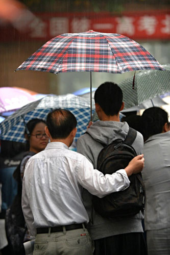 Students arrive at an exam site with their parents in Beijing, June 7, 2013. [Photo/Xinhua]