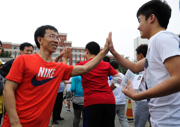 Teachers high-five students outside a test site in Changchun, Northeast China's Jilin province, June 7, 2013. [Photo/Xinhua]