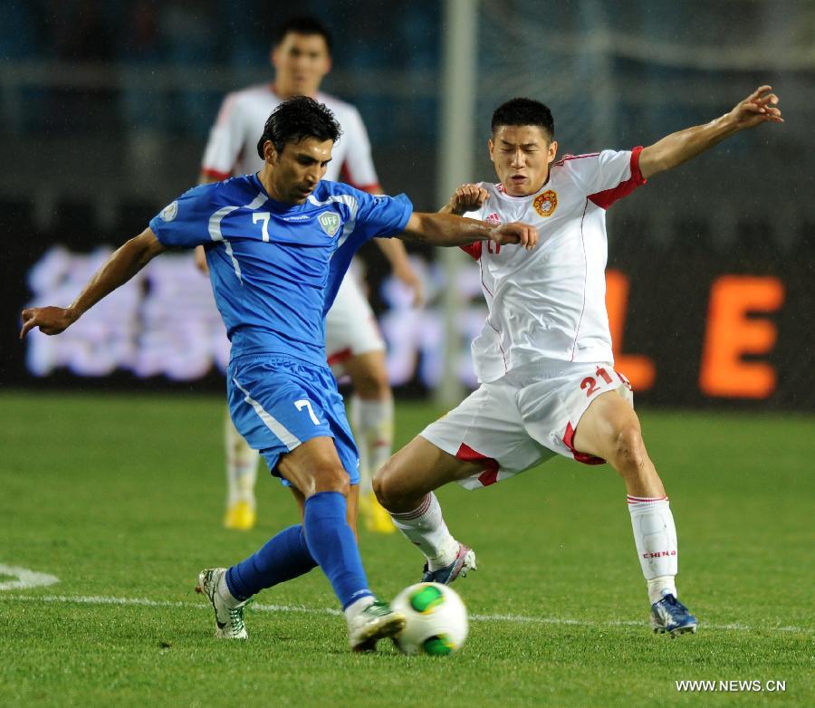 Azizibek Haydarov (L) of Uzbekistan vies with Yu Hai of China during a friendly match in Hohhot, north China's Inner Mongolia Autonomous Region, June 6, 2013. Uzbekistan won the match 2-1. (Xinhua/Zhang Ling)