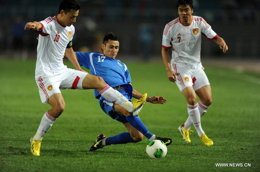 Sanjar Tursunov (C) of Uzbekistan vies with Gao Lin (L) of China during a friendly match in Hohhot, north China's Inner Mongolia Autonomous Region, June 6, 2013. Uzbekistan won the match 2-1. (Xinhua/Zhang Ling)