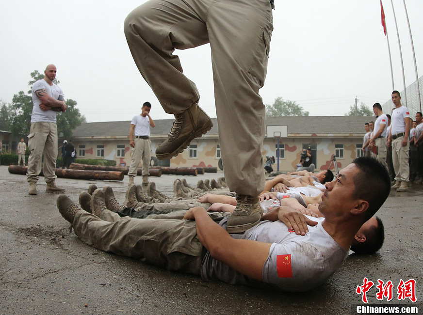 Trainees trample on fellow trainees during a VIP security training course at the Genghis Security Academy in Beijing, June 6, 2013. More than 70 trainees, including six women and three foreigners will receive high-intensity training for VIP security at a bodyguard camp in Beijing. They will train over 20 hours per day for one week. One third of the participants will be phased out at the end of the "Hell Week". (Photo/ Chinanews.com)