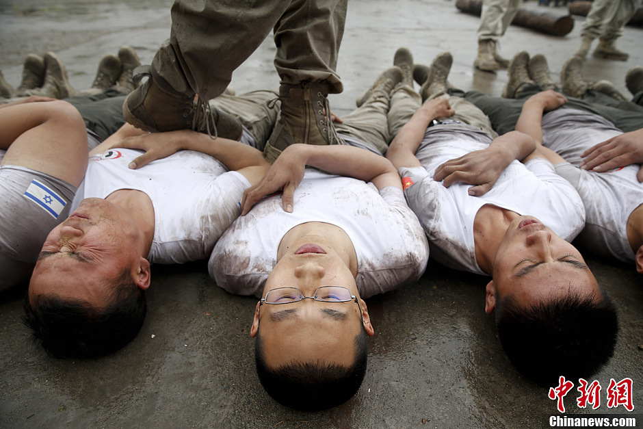 Trainees trample on fellow trainees during a VIP security training course at the Genghis Security Academy in Beijing, June 6, 2013. More than 70 trainees, including six women and three foreigners will receive high-intensity training for VIP security at a bodyguard camp in Beijing. They will train over 20 hours per day for one week. One third of the participants will be phased out at the end of the "Hell Week". (Photo/ Chinanews.com)