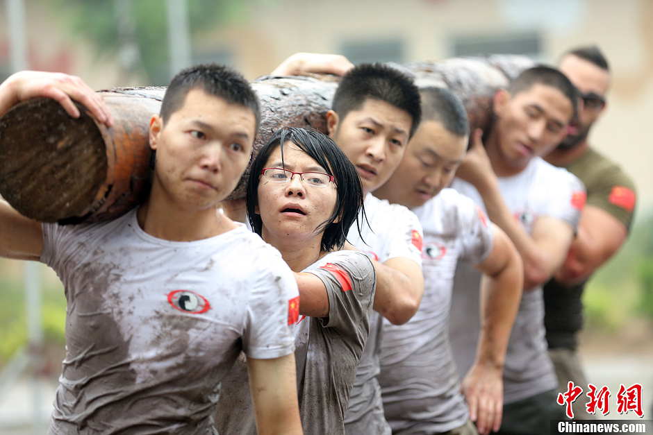 Trainees lift a log during a VIP security training course at the Genghis Security Academy in Beijing, June 6, 2013. More than 70 trainees, including six women and three foreigners will receive high-intensity training for VIP security at a bodyguard camp in Beijing. They will train over 20 hours per day for one week. One third of the participants will be phased out at the end of the "Hell Week".  (Photo/ Chinanews.com)