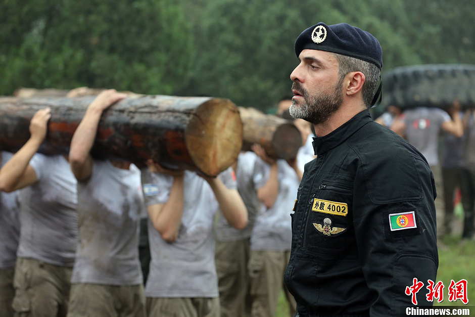 Trainees lift a log during a VIP security training course at the Genghis Security Academy in Beijing, June 6, 2013. More than 70 trainees, including six women and three foreigners will receive high-intensity training for VIP security at a bodyguard camp in Beijing. They will train over 20 hours per day for one week. One third of the participants will be phased out at the end of the "Hell Week".  (Photo/ Chinanews.com)