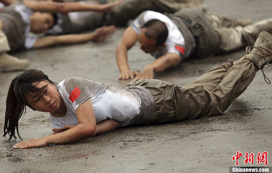 Trainees roll over the ground during a VIP security training course at the Genghis Security Academy in Beijing, June 6, 2013. More than 70 trainees, including six women and three foreigners will receive high-intensity training for VIP security at a bodyguard camp in Beijing. They will train over 20 hours per day for one week. One third of them will be eliminated. (Photo/ Chinanews.com)