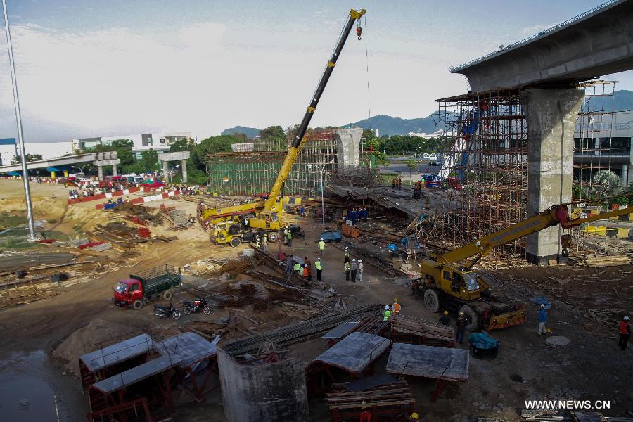 Workers of a rescue team work at the site of the collapsed bridge in the northeastern state of Penang, Malaysia, June 7, 2013. An interchange ramp to a cross-sea bridge that is under construction in northern Malaysia collapsed on Thursday, and rescue teams are still searching for survivors who might be trapped under the debris. (Xinhua) 