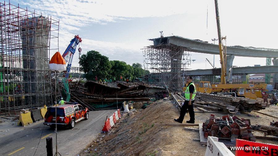 Workers of a rescue team work at the site of the collapsed bridge in the northeastern state of Penang, Malaysia, June 7, 2013. An interchange ramp to a cross-sea bridge that is under construction in northern Malaysia collapsed on Thursday, and rescue teams are still searching for survivors who might be trapped under the debris. (Xinhua) 