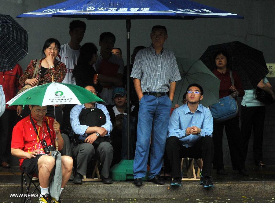 Family members of examinees of the national college entrance exam wait outside the exam sites at the Dongzhimen Middle School in Beijing, capital of China, June 7, 2013. Some 9.12 million applicants are expected to sit this year's college entrance exam on June 7 and 8. (Xinhua/Gong Lei)
