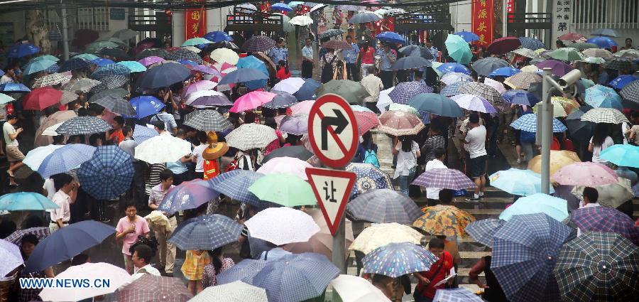 Parents send their kids to take the national college entrance exam outside a high school in Changsha, capital of central China's Hunan Province, June 7, 2013. Some 9.12 million applicants are expected to sit this year's college entrance exam. (Xinhua/Li Ga)