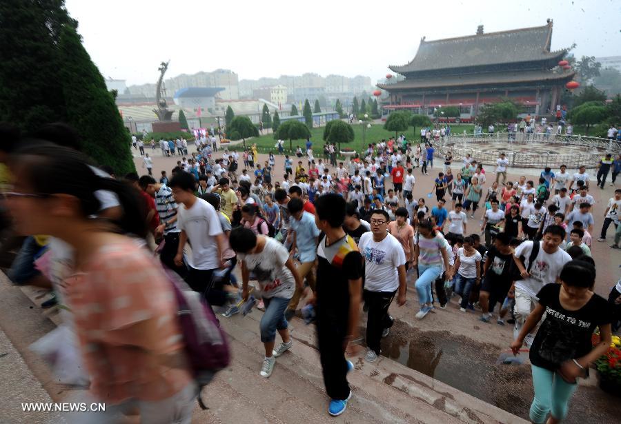 Examinees arrive to take the national college entrance exam at the Taigu Middle School in Taigu County, north China's Shanxi Province, June 7, 2013. Some 9.12 million applicants are expected to sit this year's college entrance exam on June 7 and 8. (Xinhua/Yan Yan)